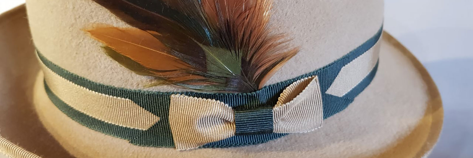 cream trilby close up showing ribbon and feather decoration